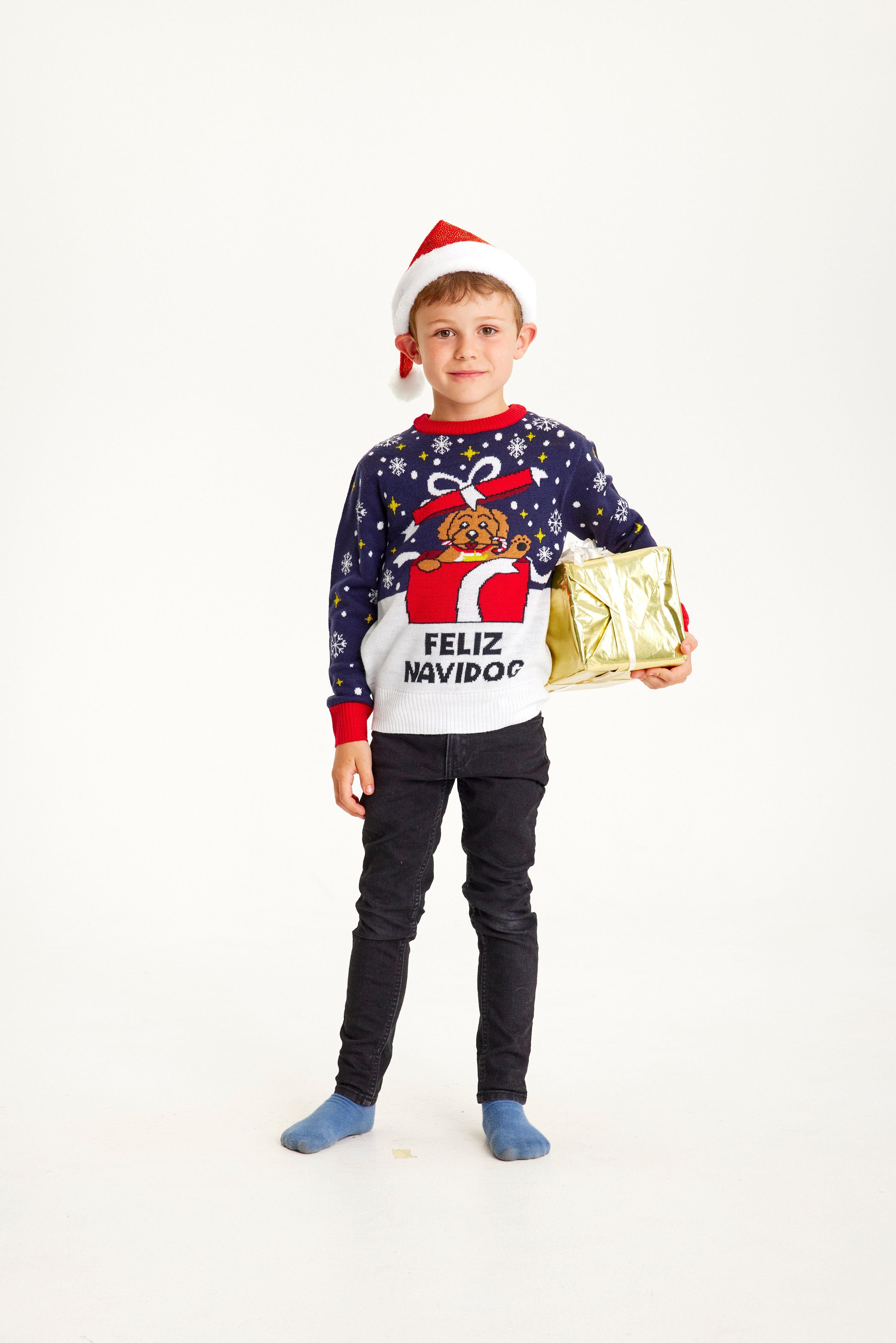 Et barn med en gave i hånden har på seg en blå julegenser med sitatet